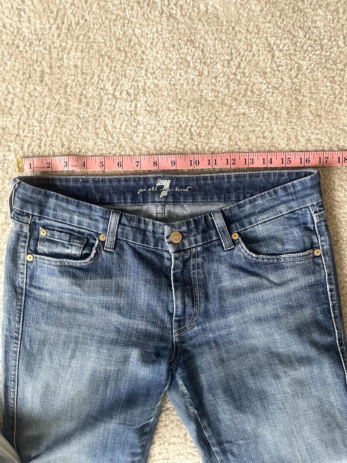 7 For All Mankind low-rise bootcut jeans featuring a medium wash Size 31