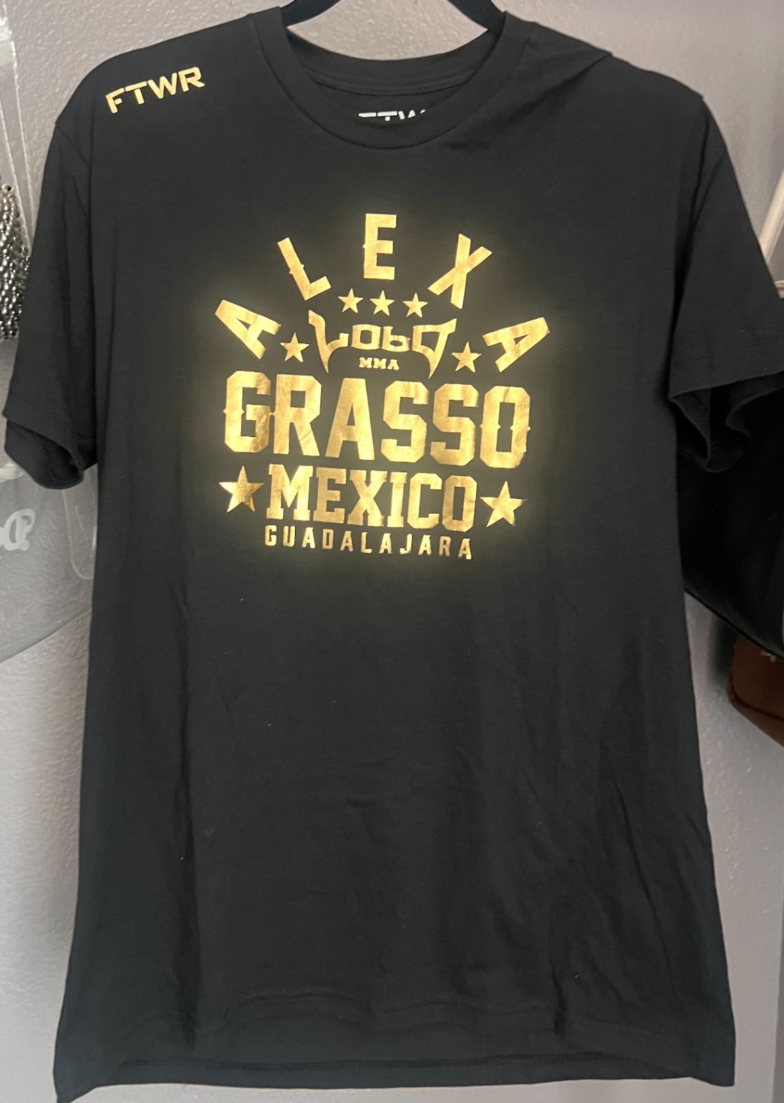 Black Alexa Grasso t-shirt with gold screen-printed graphics. Large