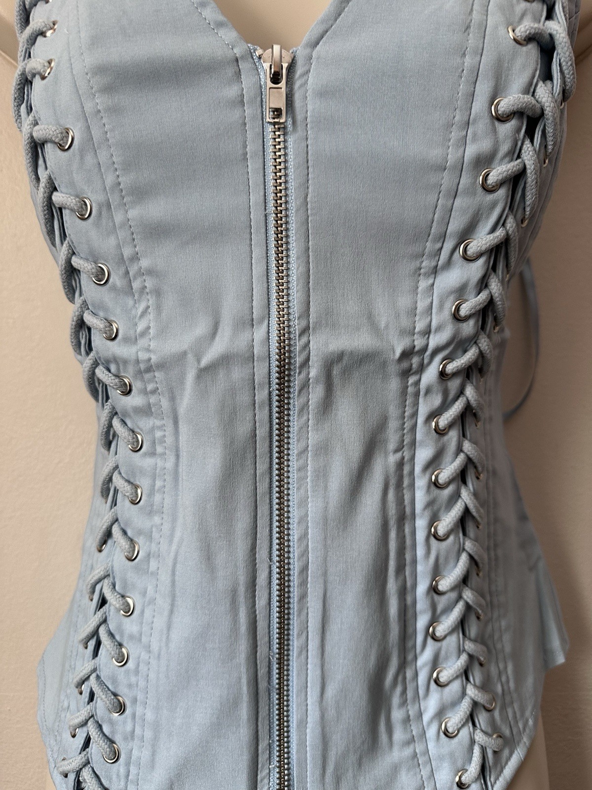 Light blue corset top with zipper and lace up details