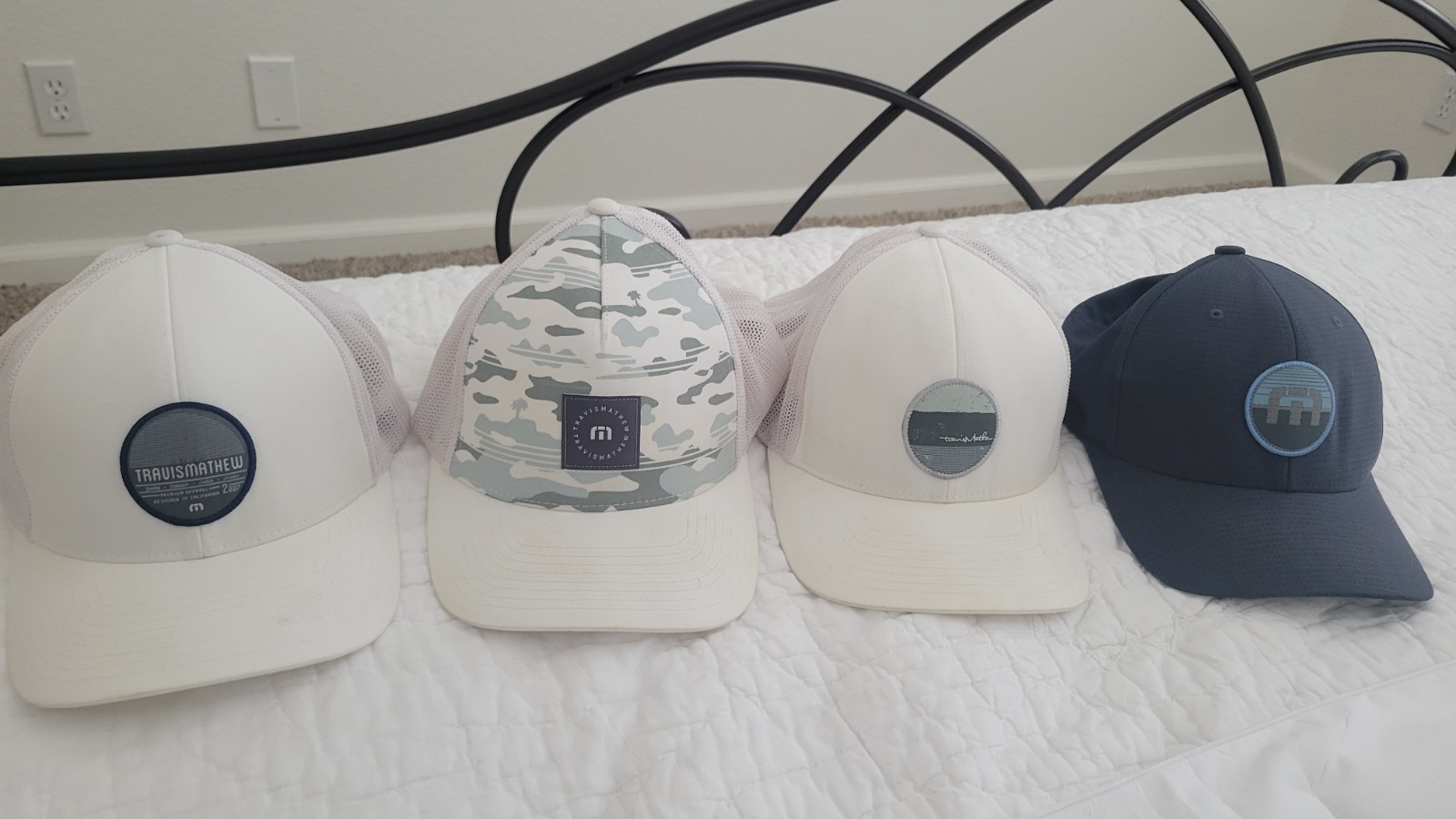 Lot of 4 TravisMathew golf/baseball caps in assorted styles and colors.