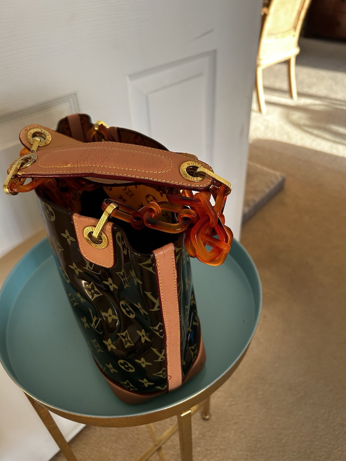 Purse vinyl exterior,amber-colored resin chain straps, and gold-tone hardware