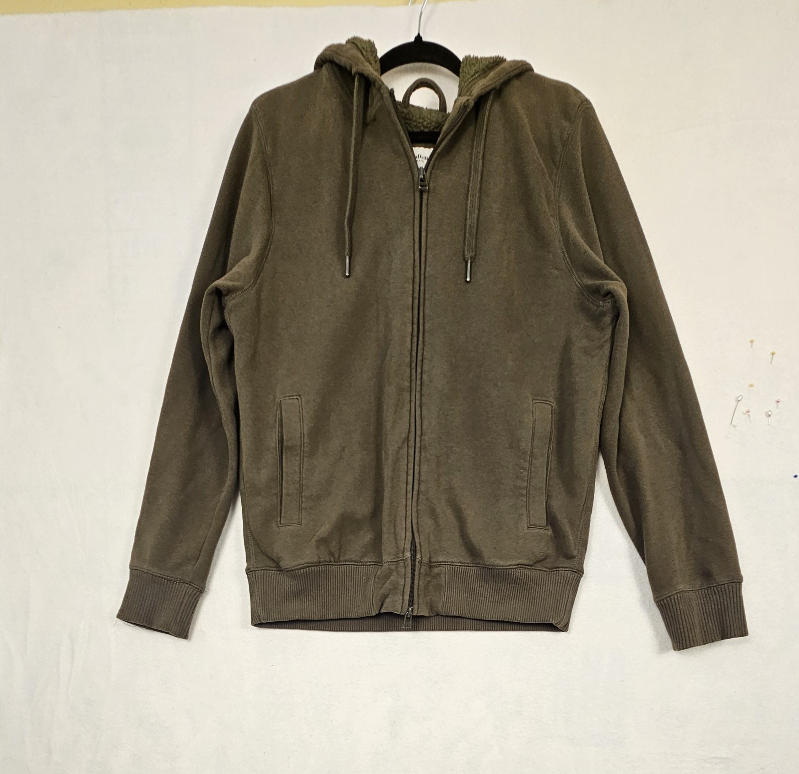 olive green full-zip hoodie features a cozy fleece lining, an adjustable drawstr