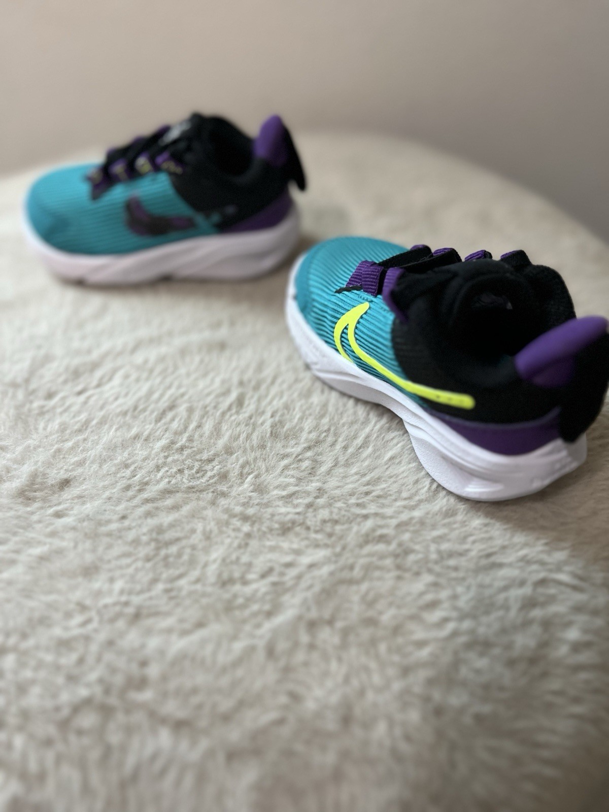 Nike Star Runner 4 sneakers in a teal, purple, and volt colorway Infant Size 4c