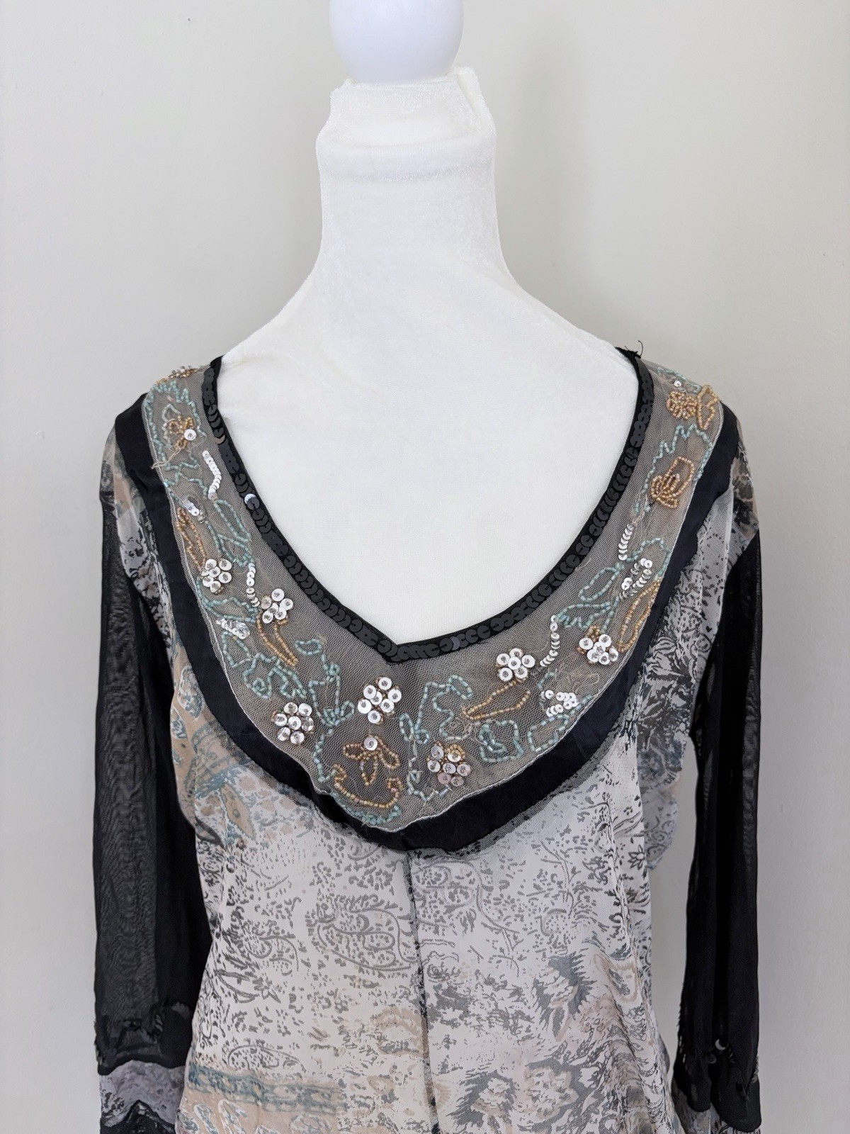 Vintage long sleeve top features a grey and black paisley print with intricate b